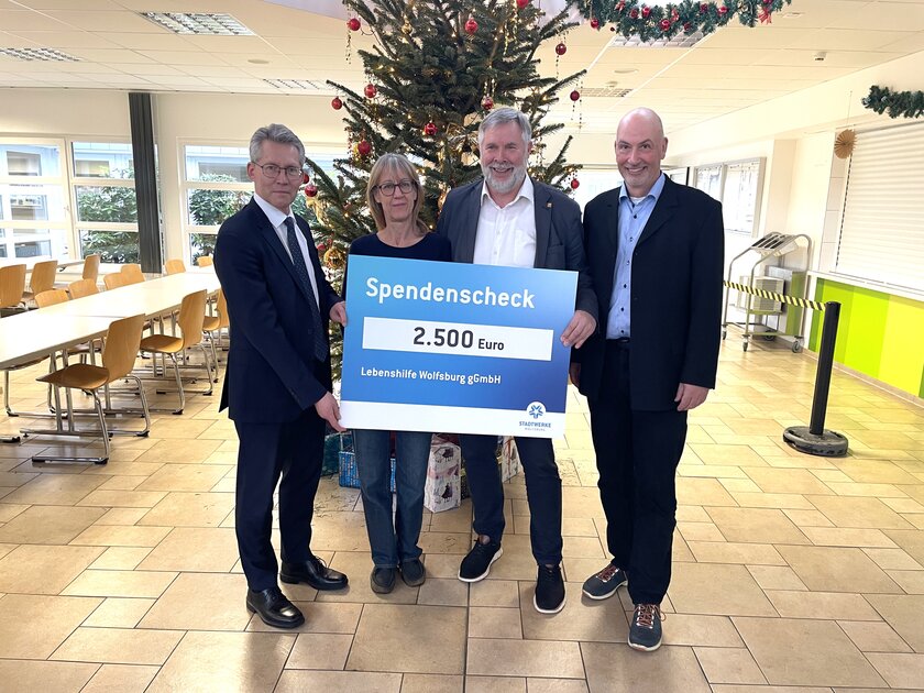 Sie halten den Spendencheck und stehen vor einem Weihnachtsbaum.von links: Stadtwerke Vorstand Dr. Frank Kästner, Conny Neumann Mitarbeiterin der „Offenen Hilfen“, Vorsitzender der Lebenshilfe e.V. Siebert Kloster und Lebenshilfe Geschäftsführer Marcus Weinreich.