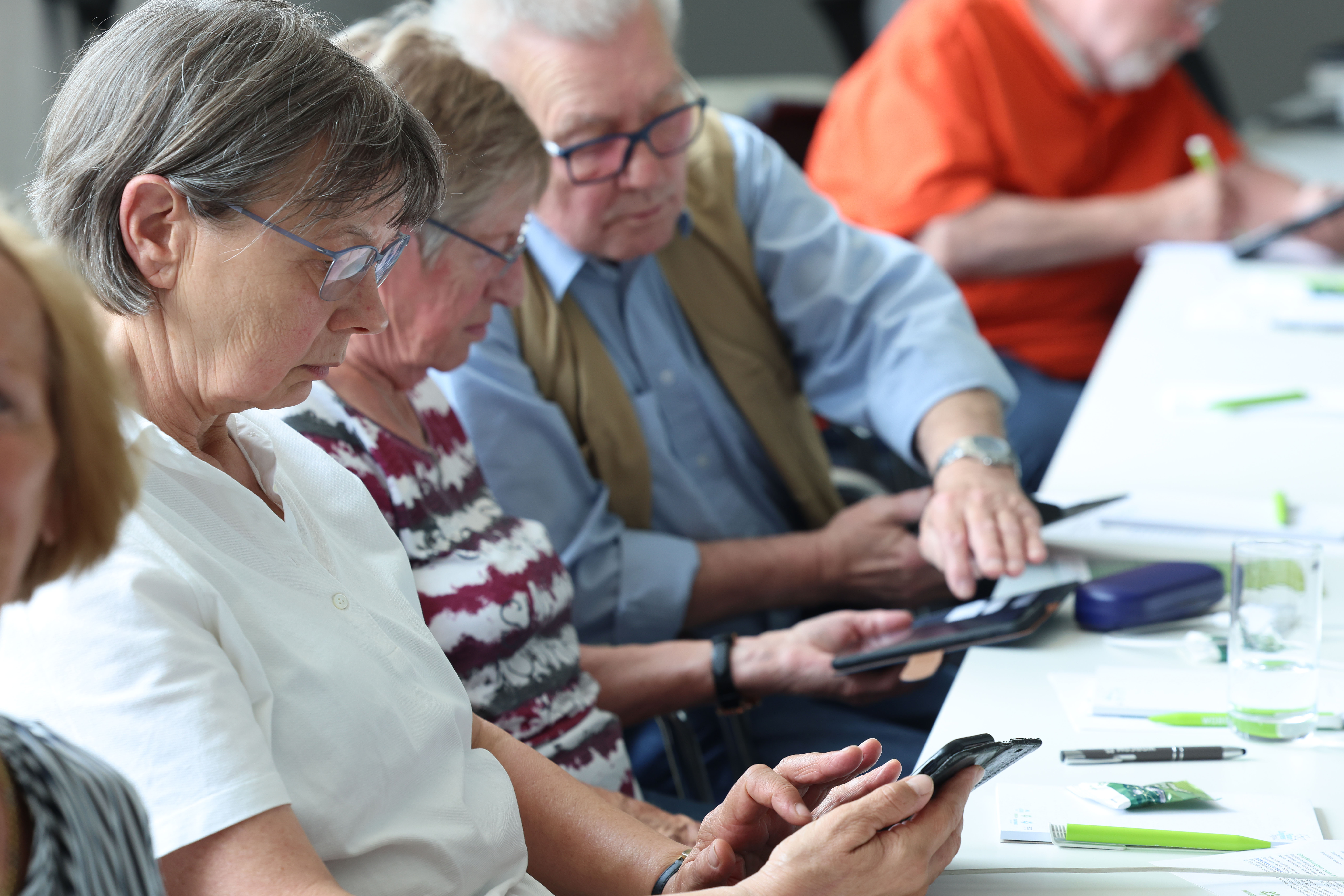 Rentner nehmen an einer Smartphone Schulung teil